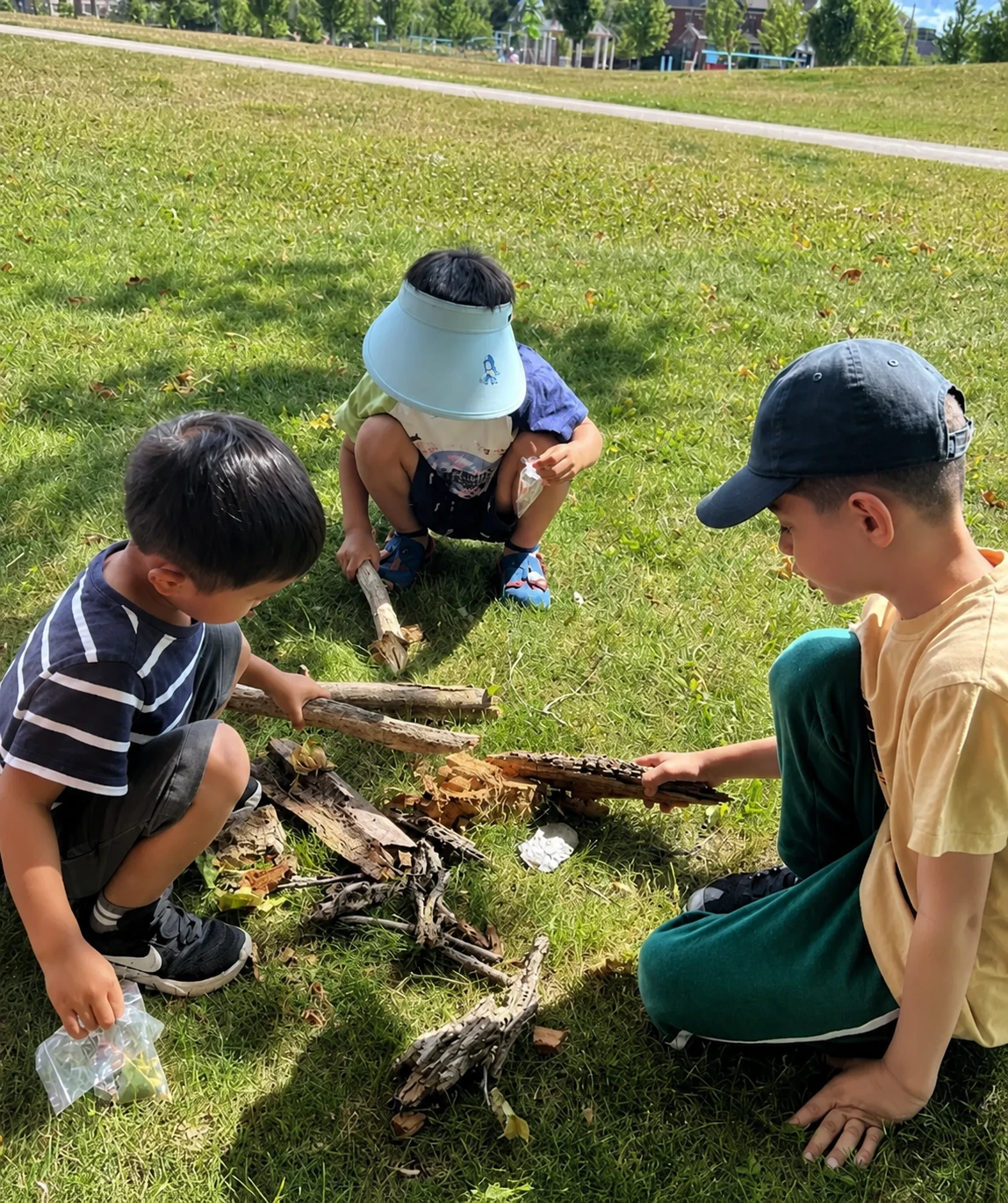 School-age children exploring natural materials together outdoors.